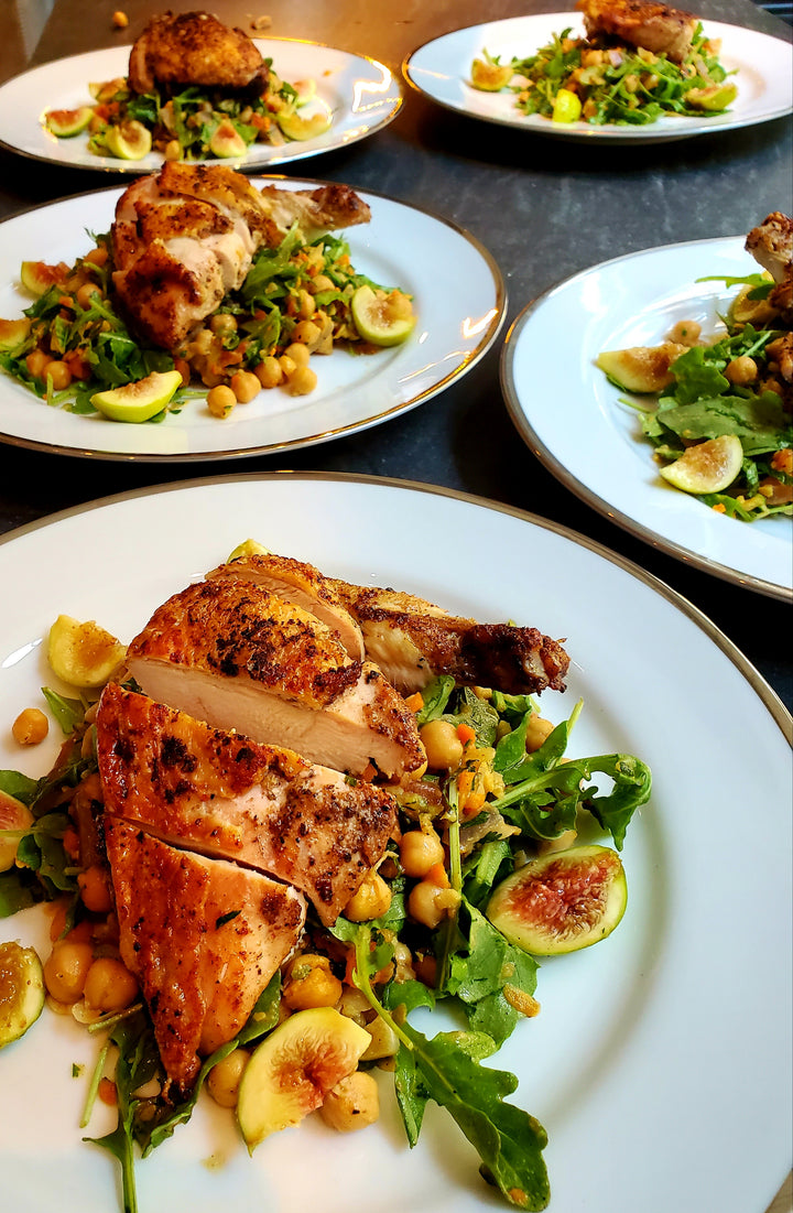 Plates of roasted chicken with salad on a Marble Counter top
