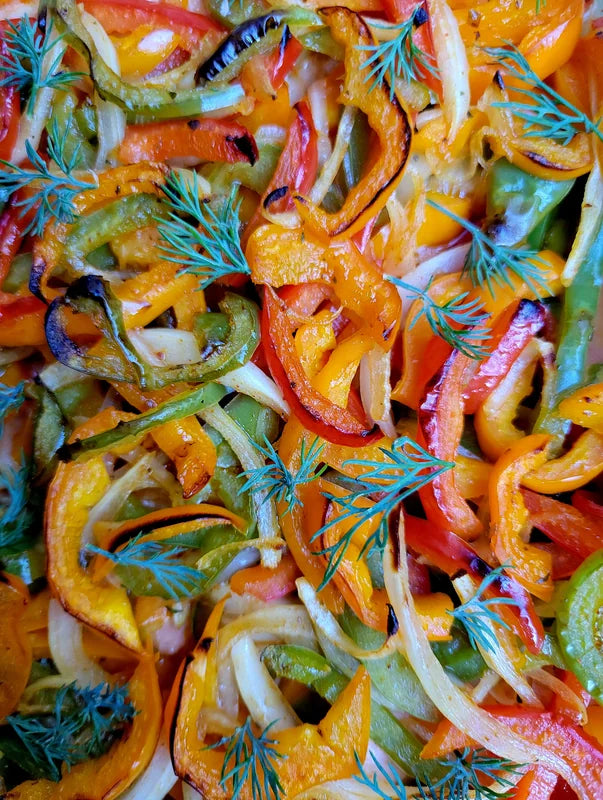 A close view of brightly coloured sliced vegetables and herbs.