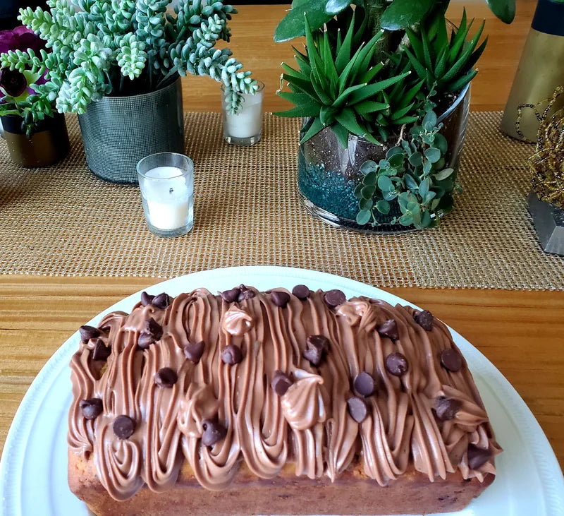 A decorated chocolate dessert on a white plate at the table.